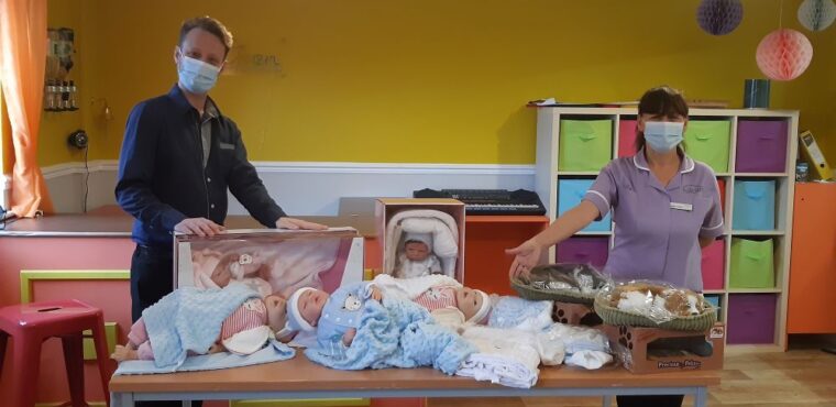 staff showing therapy dolls